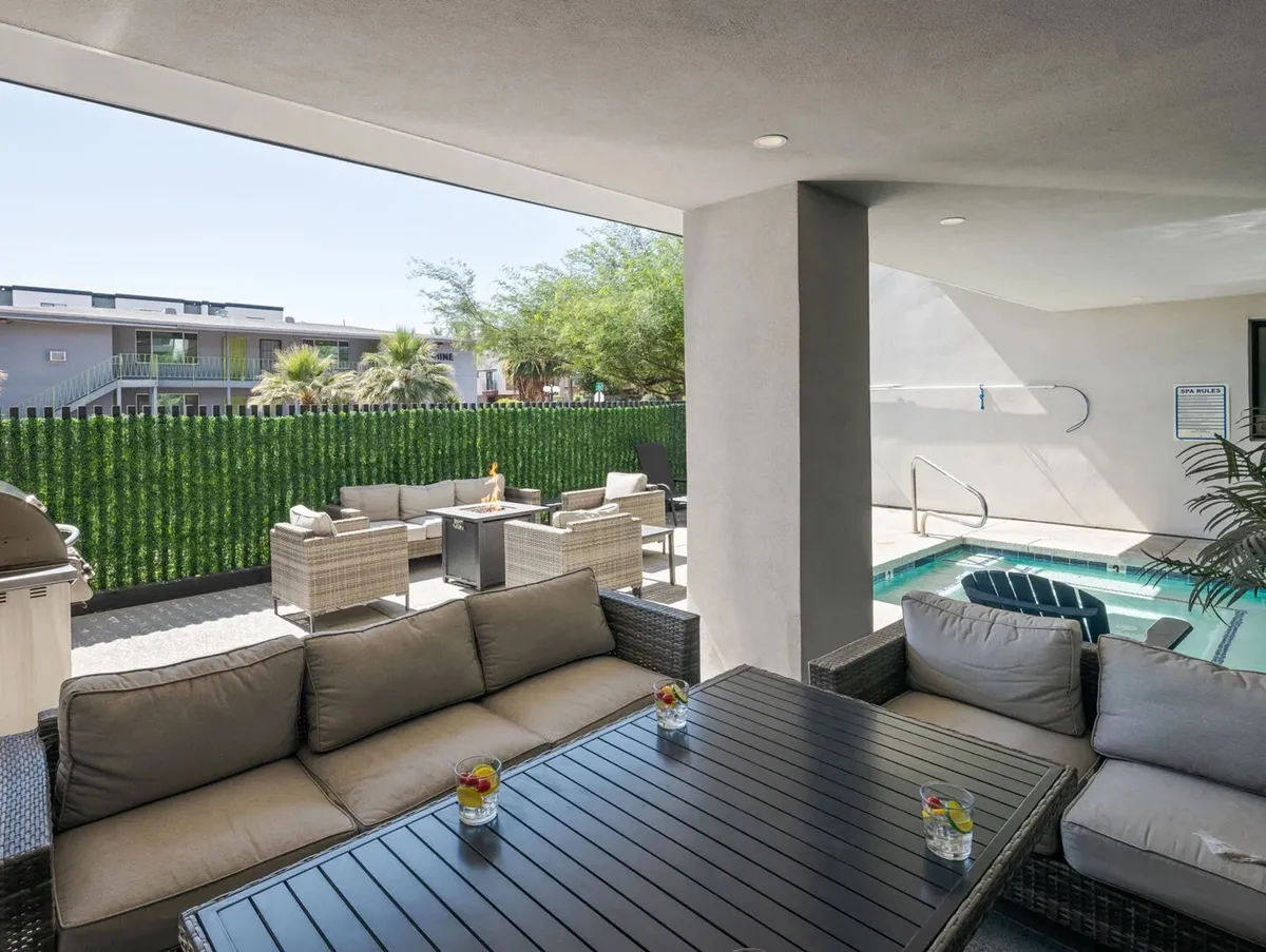 An inviting exterior space featuring a swimming pool, outdoor seating surrounded by lush greenery, and a table with drinks, all set under a serene sky. This environment encourages relaxation and socializing after work hours, embodying the 'play' aspect of the section.