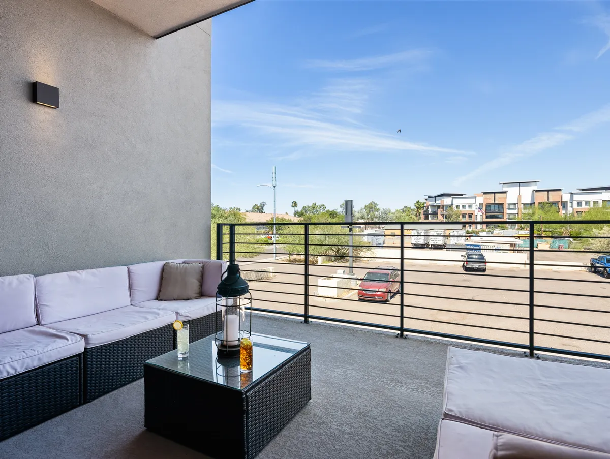 A tranquil outdoor seating area with a glass-top table and lantern, surrounded by greenery. The scene suggests a peaceful spot for couples or friends to relax and enjoy private moments, possibly with a morning coffee or evening conversation.
